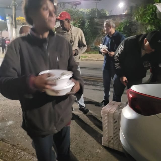 Pessoa recebendo uma refeição do projeto